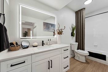 A bathroom with a white countertop and a white toilet. at The Laurel Apartments, Chandler, AZ